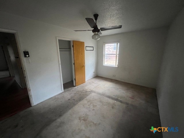 unfurnished bedroom with ceiling fan, a textured ceiling, and a closet