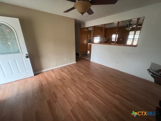 unfurnished living room with ceiling fan and hardwood / wood-style flooring