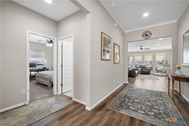 corridor with recessed lighting, baseboards, wood finished floors, and ornamental molding