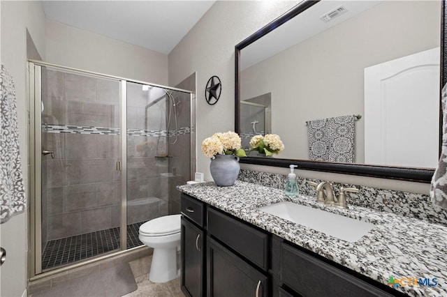 bathroom featuring a stall shower, visible vents, toilet, tile patterned floors, and vanity