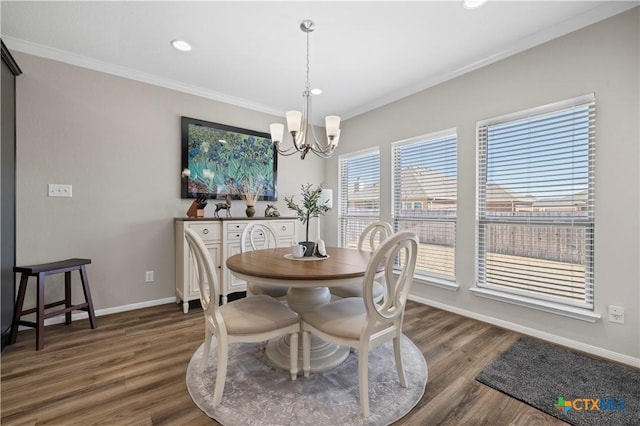 dining room featuring baseboards, ornamental molding, wood finished floors, an inviting chandelier, and recessed lighting