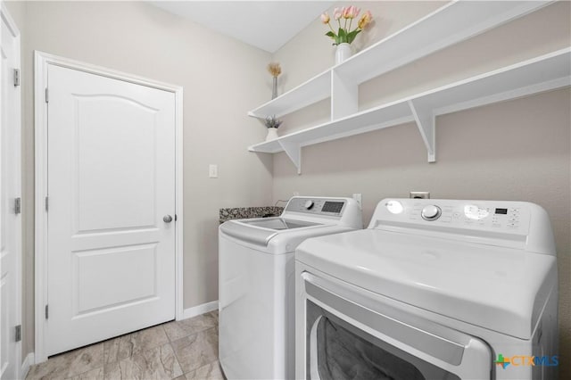 washroom with laundry area, baseboards, and washing machine and clothes dryer