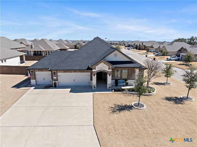 french country home with fence, a garage, a residential view, stone siding, and driveway