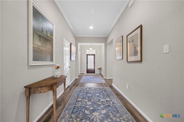 entryway with ornamental molding, dark wood-style flooring, and baseboards