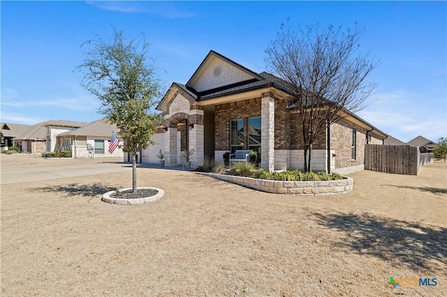 view of front of house featuring a porch, a garage, brick siding, fence, and driveway