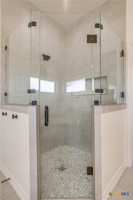 bathroom featuring tile patterned floors and a shower with door