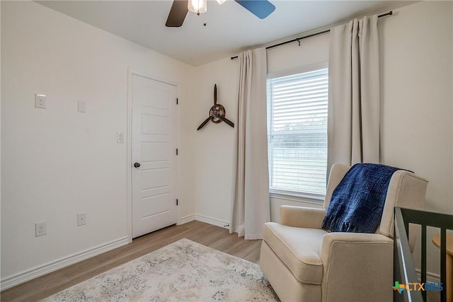 living area with ceiling fan, light hardwood / wood-style floors, and a wealth of natural light