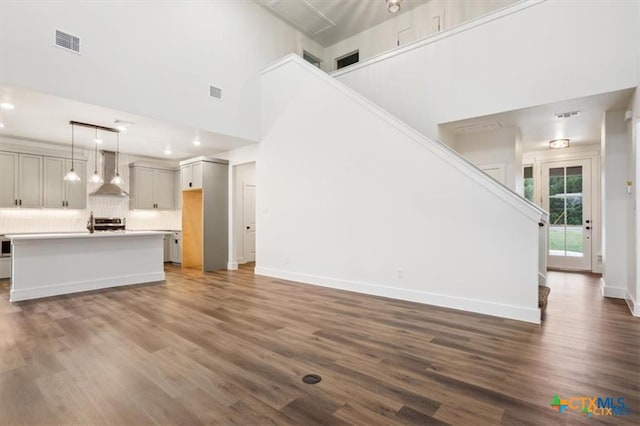 unfurnished living room featuring dark hardwood / wood-style floors and a high ceiling