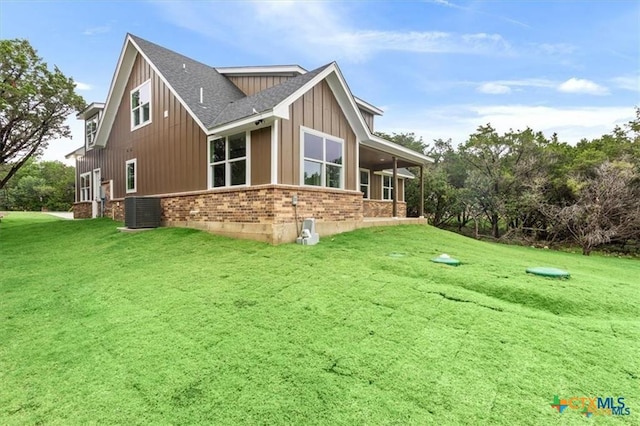 back of property featuring cooling unit and a yard