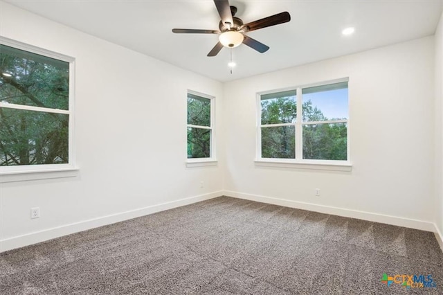 carpeted spare room featuring ceiling fan