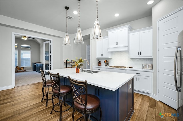 kitchen with wood finished floors, visible vents, appliances with stainless steel finishes, and a sink