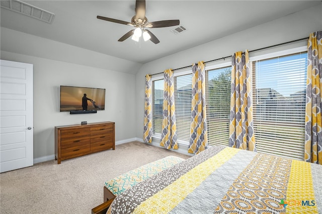 carpeted bedroom featuring a ceiling fan, lofted ceiling, baseboards, and visible vents