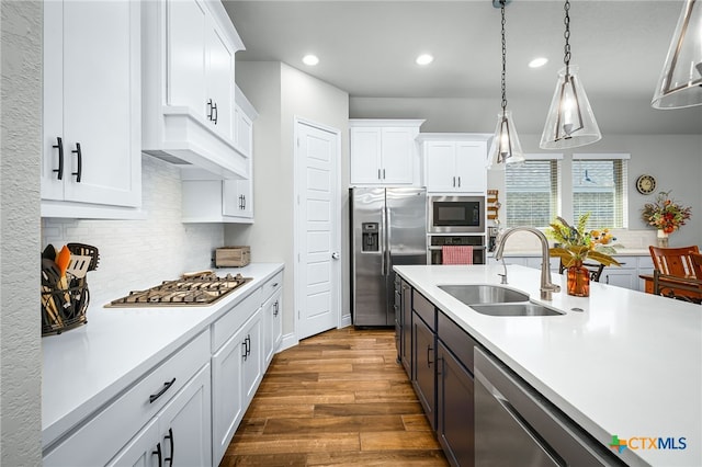 kitchen featuring light countertops, white cabinets, appliances with stainless steel finishes, and a sink