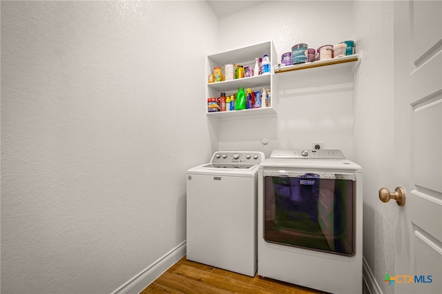 laundry room with washer and clothes dryer, laundry area, baseboards, and wood finished floors