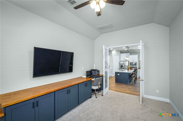 office with visible vents, light colored carpet, a ceiling fan, and lofted ceiling