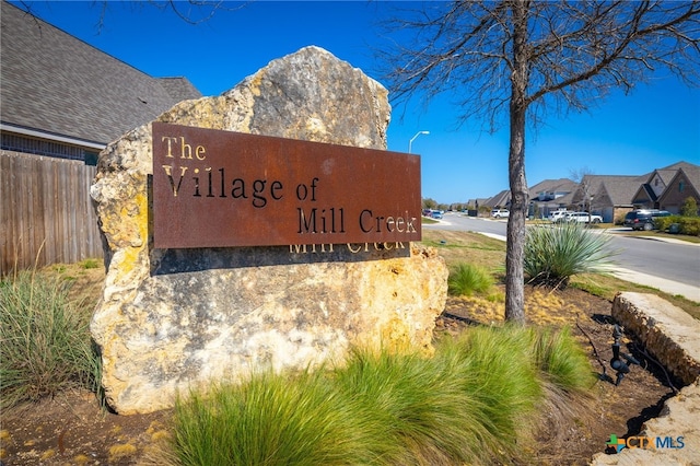 community sign featuring a residential view and fence