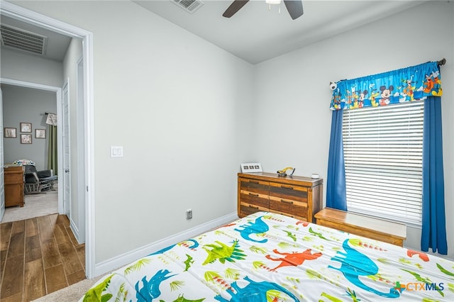 bedroom featuring ceiling fan, visible vents, baseboards, and dark wood-style floors