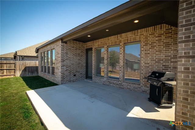 view of patio with a grill and fence