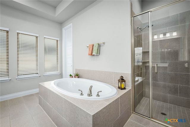 bathroom featuring a garden tub, tile patterned floors, baseboards, and a shower stall