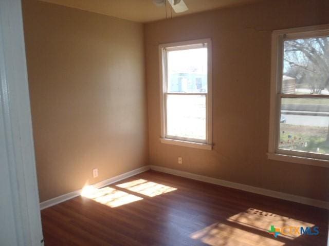 unfurnished room featuring ceiling fan, wood finished floors, and baseboards