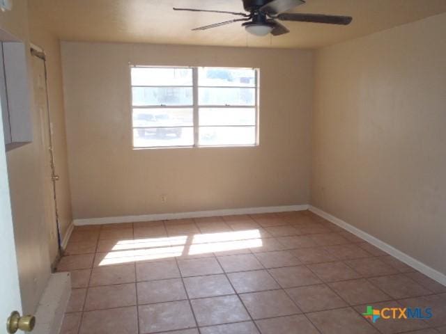 unfurnished room featuring ceiling fan, baseboards, and light tile patterned floors