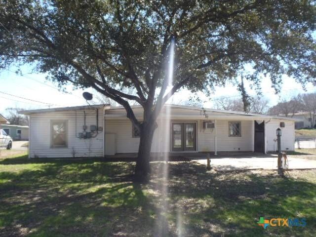 single story home featuring french doors and a front lawn