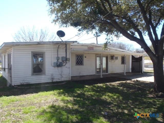 rear view of house featuring a yard and french doors