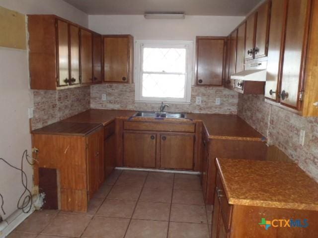 kitchen featuring brown cabinets and a sink