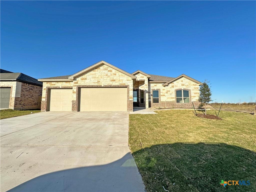 ranch-style house with a garage and a front yard