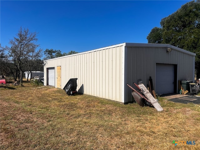 view of outbuilding with a garage and a yard