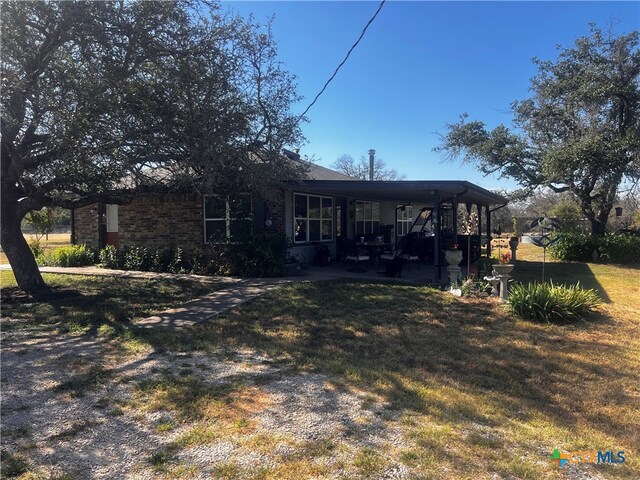 rear view of property featuring a lawn