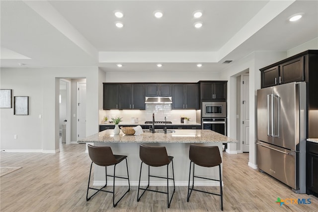117 Ace Ln Unit 101, San Marcos, TX 78666 - kitchen with stainless steel appliances, decorative backsplash, a kitchen breakfast bar, light stone countertops, and recessed lighting