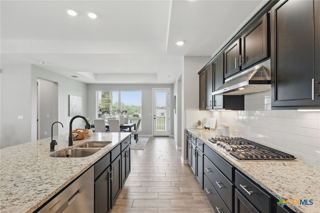 117 Ace Ln Unit 101, San Marcos, TX 78666 - kitchen with appliances with stainless steel finishes, backsplash, under cabinet range hood, light stone countertops, and recessed lighting