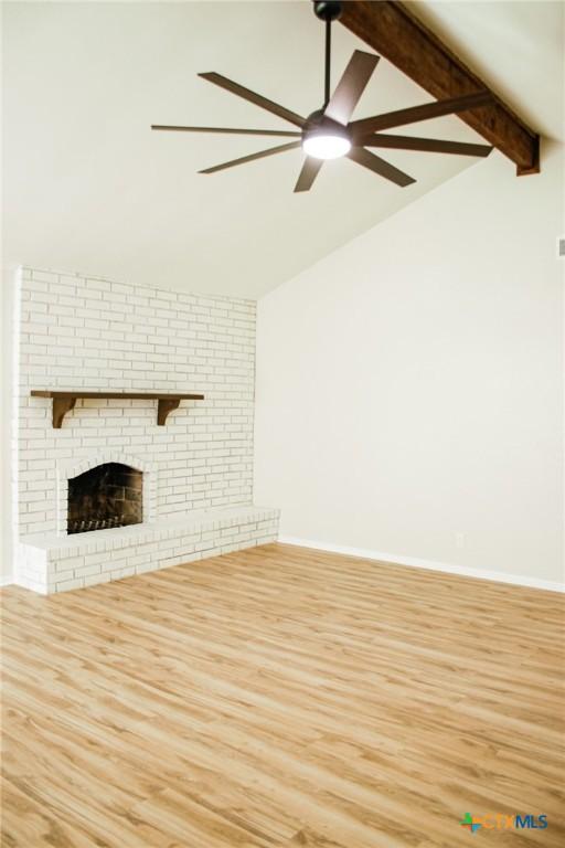 211 Alamogordo Dr, Victoria, TX 77904 - unfurnished living room featuring wood finished floors, a ceiling fan, and a fireplace