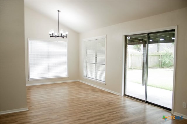 211 Alamogordo Dr, Victoria, TX 77904 - unfurnished dining area featuring a chandelier, lofted ceiling, wood finished floors, and healthy amount of natural light