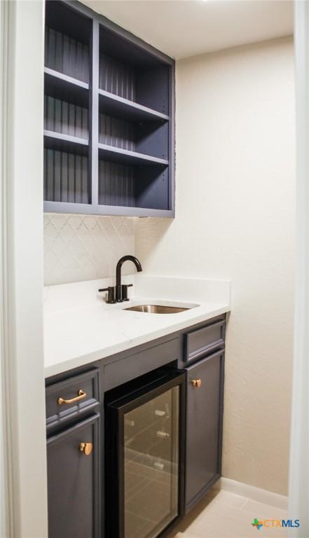 211 Alamogordo Dr, Victoria, TX 77904 - bar featuring wine cooler and decorative backsplash