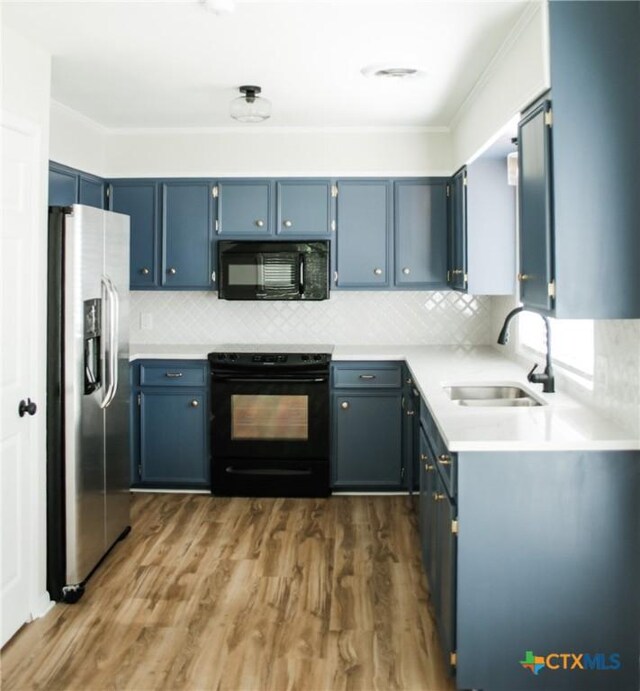 211 Alamogordo Dr, Victoria, TX 77904 - kitchen featuring black appliances, blue cabinets, backsplash, light countertops, and crown molding