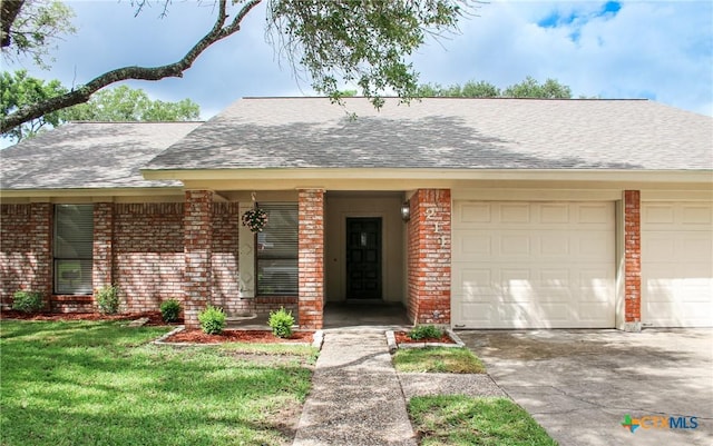 211 Alamogordo Dr, Victoria, TX 77904 - view of front of property featuring brick siding, an attached garage, roof with shingles, and driveway