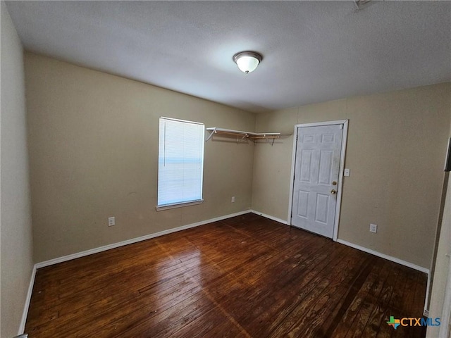 empty room with dark hardwood / wood-style flooring