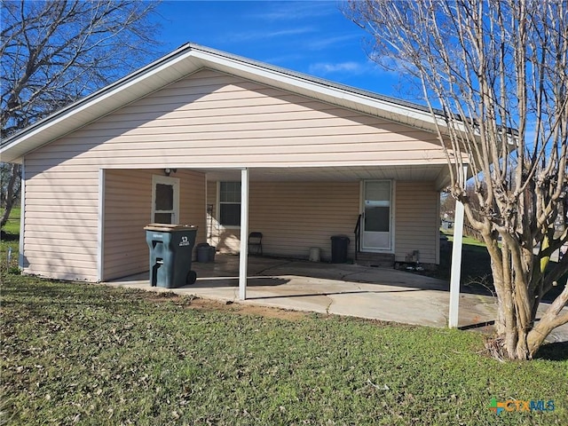 rear view of house with a lawn and a patio area