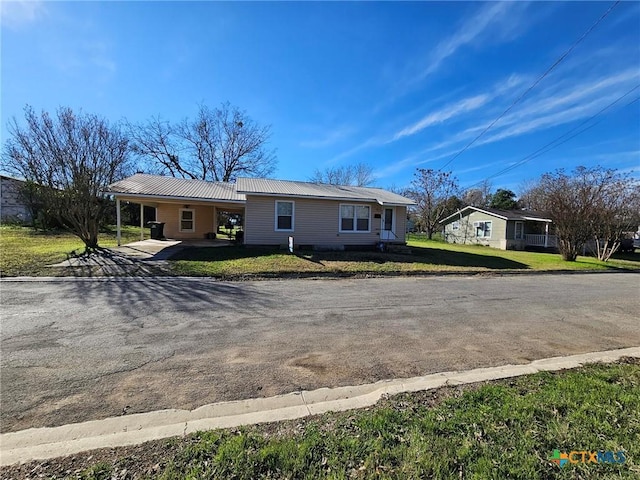 ranch-style house featuring a carport and a front yard