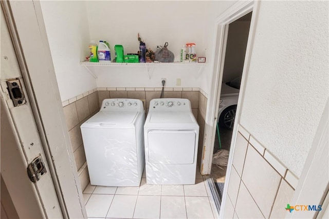 806 S 23rd St, Copperas Cove, TX 76522 - washroom featuring washer and dryer, wainscoting, light tile patterned floors, and tile walls