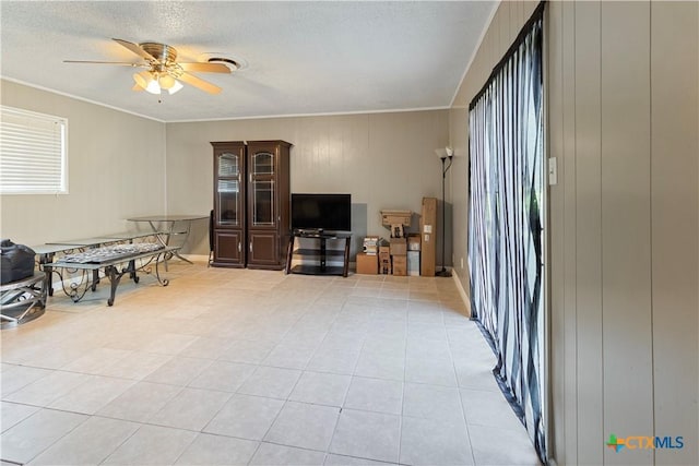 806 S 23rd St, Copperas Cove, TX 76522 - living area with ceiling fan, crown molding, light tile patterned floors, and a textured ceiling