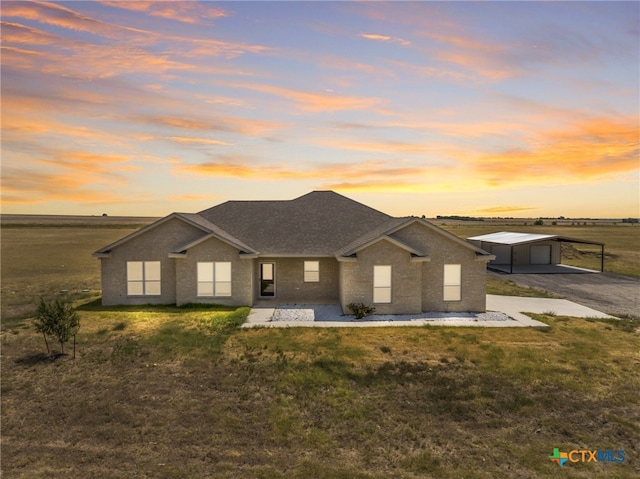 view of front of house with a carport, a garage, and a lawn