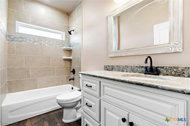 full bathroom with tiled shower / bath combo, wood-type flooring, vanity, and toilet