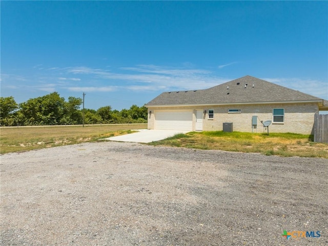 view of side of property featuring a garage and central air condition unit