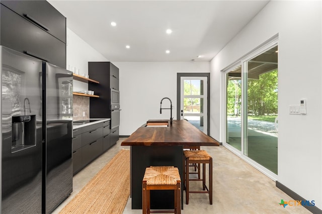 105 Schroeder St, Lockhart, TX 78644 - kitchen featuring a sink, recessed lighting, stainless steel fridge with ice dispenser, open shelves, and wood counters