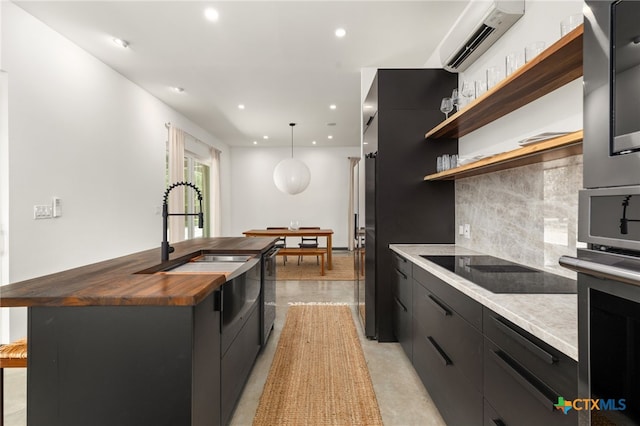 105 Schroeder St, Lockhart, TX 78644 - kitchen featuring recessed lighting, an AC wall unit, black electric stovetop, wood counters, and tasteful backsplash