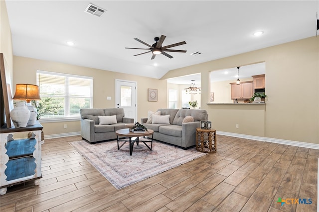 living room with hardwood / wood-style flooring and ceiling fan with notable chandelier