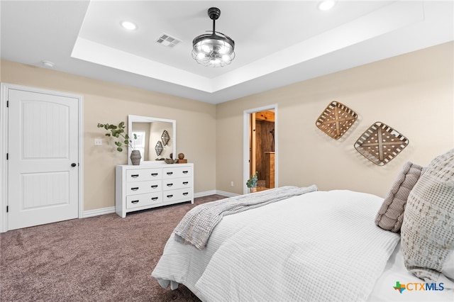 bedroom with a tray ceiling and carpet floors